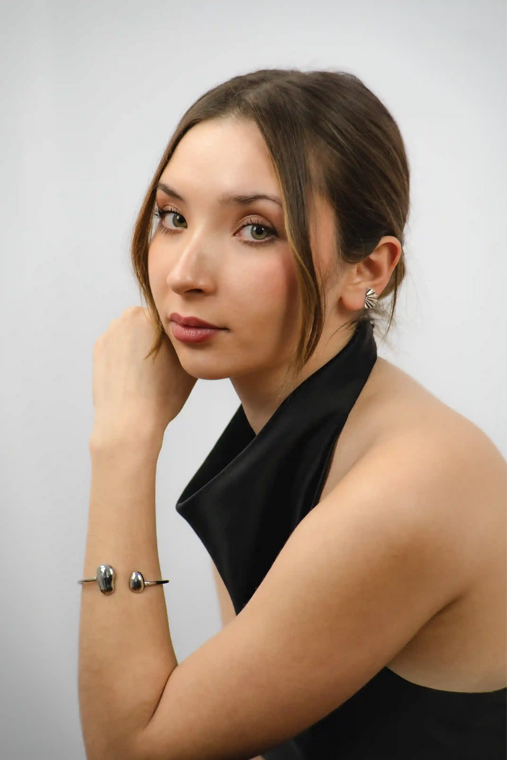Woman wearing a black top against a plain background