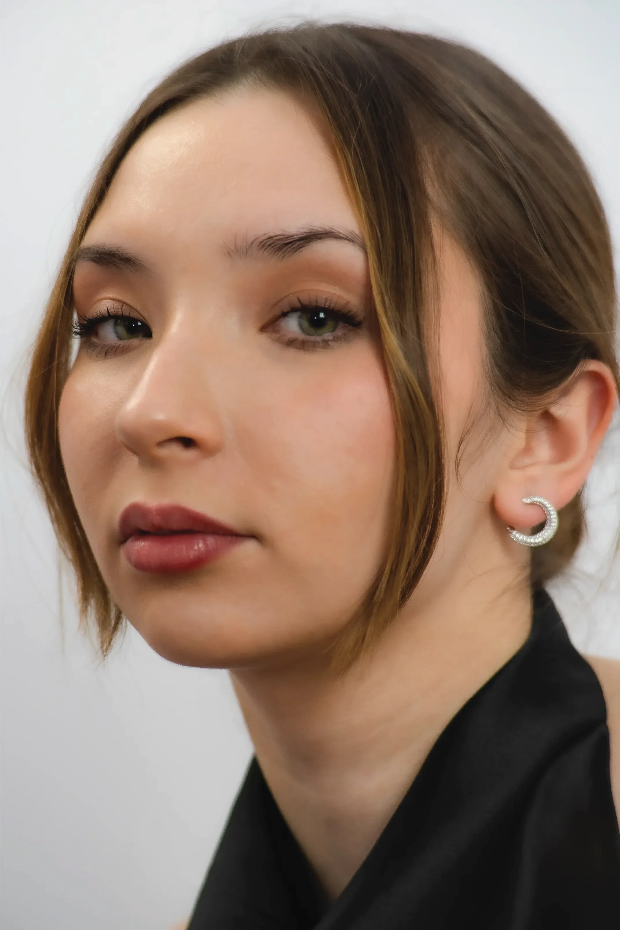Close-up of a woman with a neutral expression against a plain background