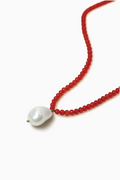 Necklace with red beads and a white pearl on a white background