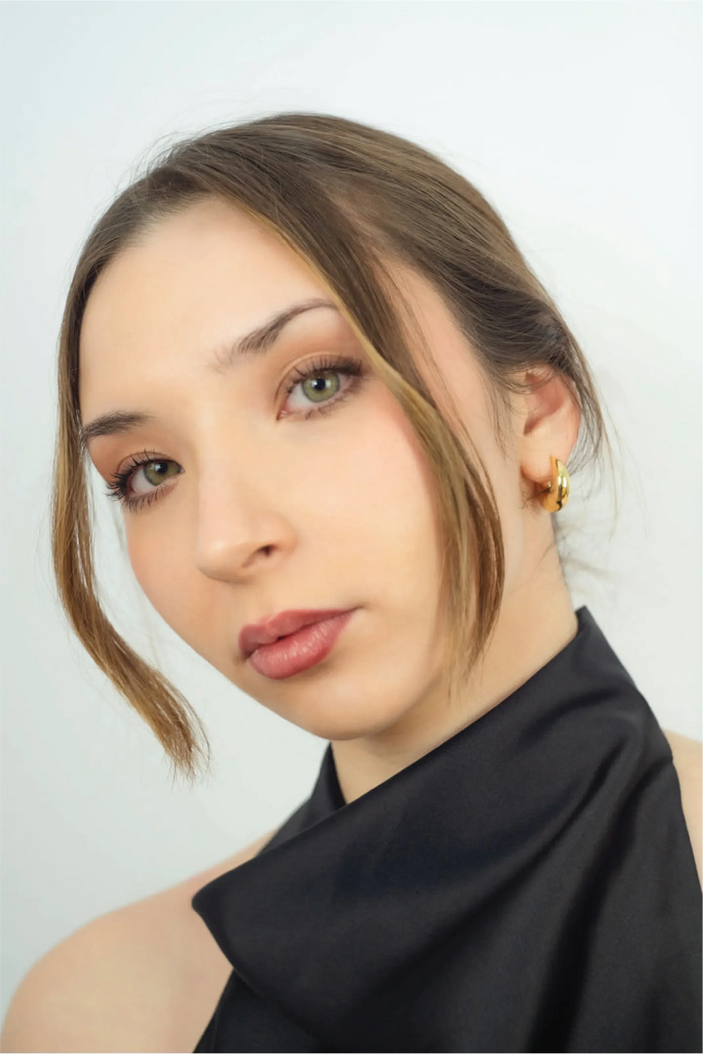 Gold hoop and teardrop earrings on a white background