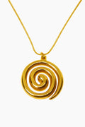 Gold spiral pendant on a gold chain against a white background
